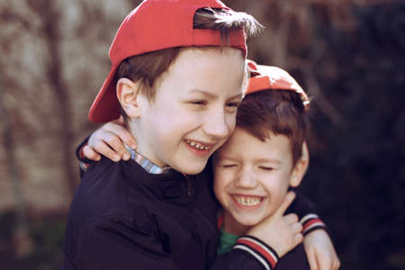 Little brothers in cap, outdoor portrait