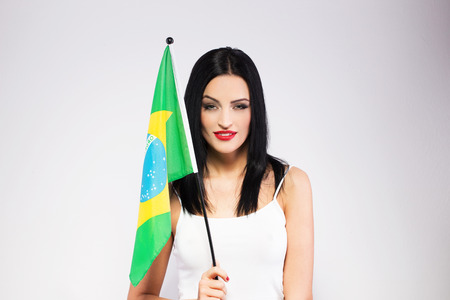 Young woman holding brazil flag, studio portraitの写真素材