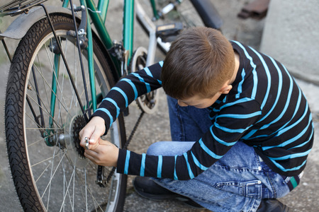 Little boy repairing bicycle outdoor at srpingの写真素材