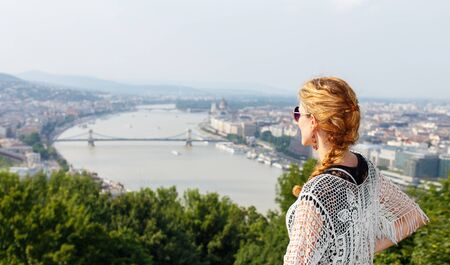 Young redhead woman posing with Budapest panorama at Citadellaの写真素材