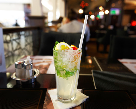 Glass of lemonade with straw in restaurant, indoorの写真素材