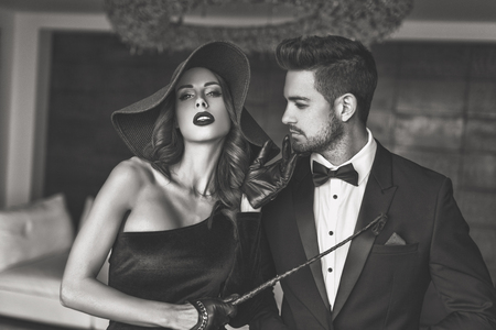 Sexy dominatrix with whip playing with rich man, black and white, bdsmの写真素材