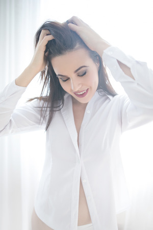 Emotional young woman in white shirt, morningの写真素材