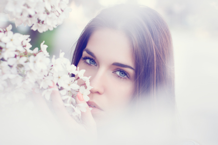 Young woman smell cherry tree blossom outdoor portraitの写真素材