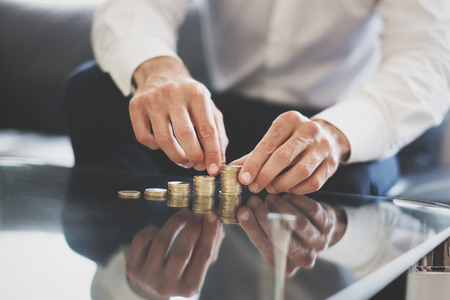 Businessman hands building money columns on glass desk, investmentの写真素材