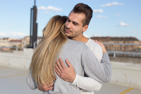 Young man cuddle girlfriend outdoors, understanding and loveの写真素材