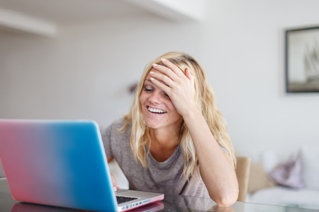Blonde woman with laptop forget something buy in online store, facepalm