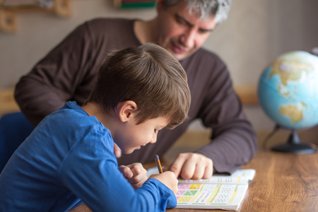 Caucasian father and son doing mathematics homework at deskの写真素材