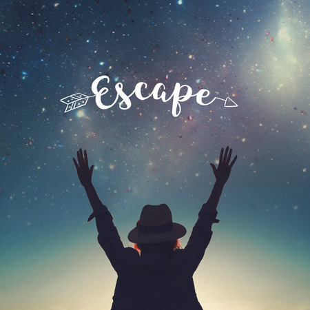 Carefree woman in hat silhouette hands up in the air to the stars, escape conceptの写真素材