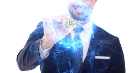 Happy businessman with bitcoin coin and blue glowing flame on whiteの写真素材