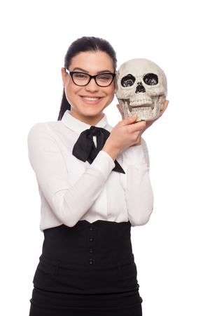 Young businesswoman and skull smiling together, isolated on whiteの写真素材