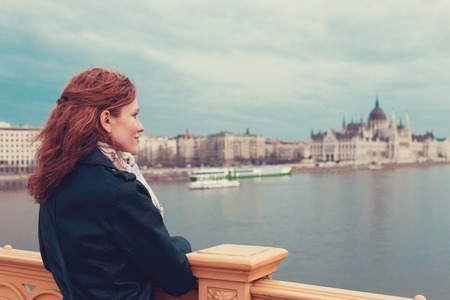 Redhead tourist woman enjoying Budapest panorama in cold weather, Hungary, Europeの写真素材