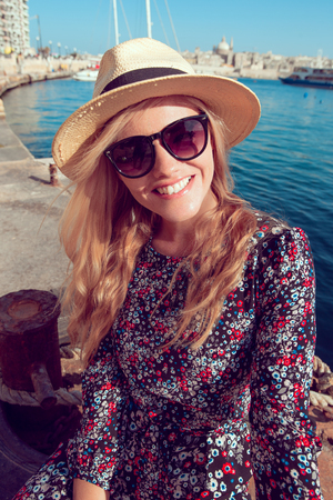 Happy young blonde woman toothy smile at Mediterranean seaの写真素材