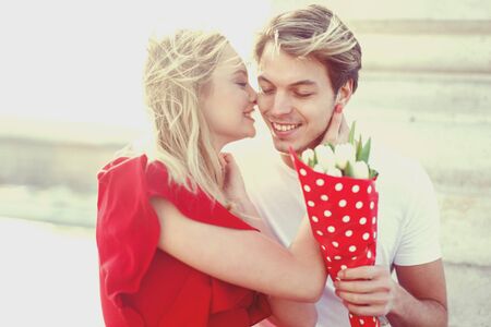 Happy young couple on dating with bouquet portrait outdoorの写真素材