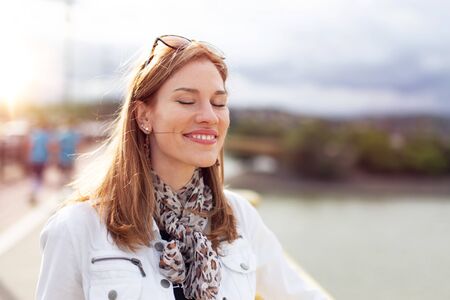 Young fashionable brunette woman enjoying sunshine at autumnの写真素材