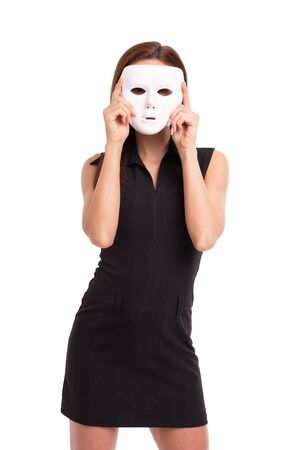 Young woman holding white mask in front of face, isolated on whiteの写真素材
