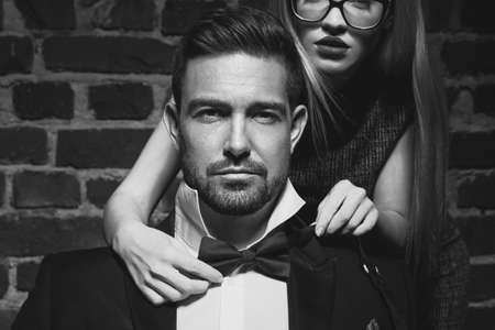 Young woman tie bow for  man in tuxedo black and whiteの写真素材