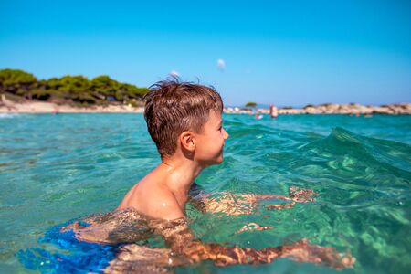Little Caucasian boy swimming in sea at Greece on summerの写真素材