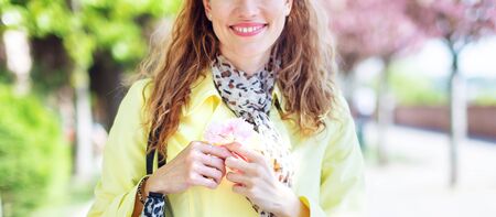 Young cheerful natural woman holding cherry blossom at springtime Sakura, bannerの写真素材