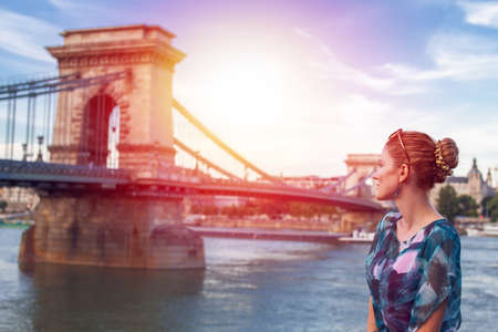 Young woman posing at Szechenyi Chain Bridge in Budapest with light of hope, Hungaryの写真素材