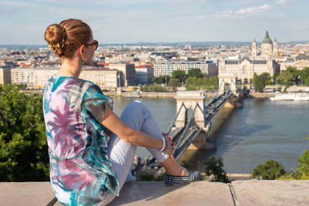 Young redhead Caucasian 20s woman sitting in Budapest panorama, Hungaryの写真素材