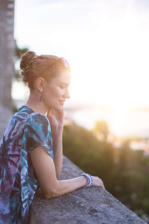 Young adult woman daydreaming about love in sunset