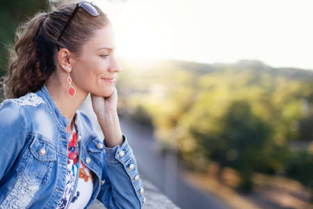 Young woman in denim jacket at autumn looking away in park