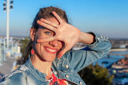 Cheerful 30s urban woman holding hair in Budapest panorama, Hungary