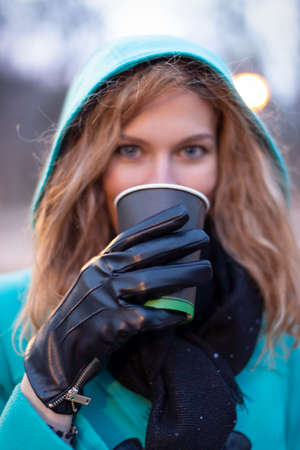 Young redhead woman drink hot coffee at outdoors depth of fieldの写真素材