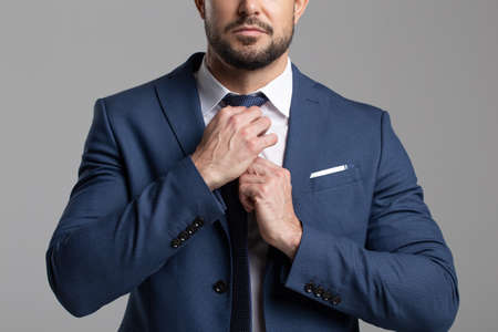 Confident professional businessman adjusting the tie conceptの写真素材