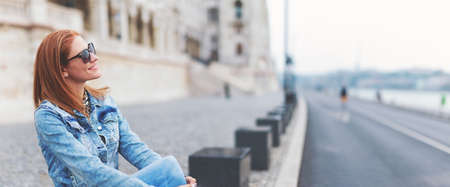 Young cheerful redhead hungarian woman relaxing at Parliament building, Budapest, Hungaryの写真素材