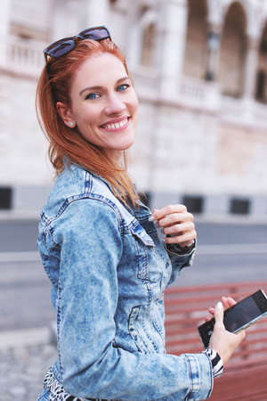 Young cheerful redhead positive urban woman toothy smiling into cameraの写真素材