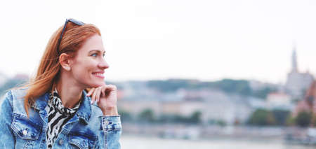 Happy young redhead Caucasian traveler woman enjoying cityscape banner