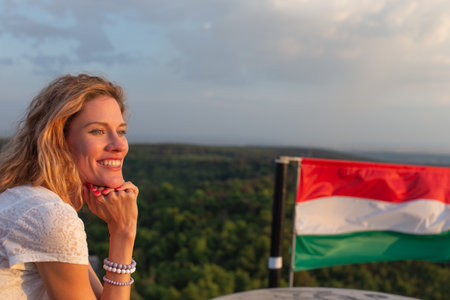 Happy young cheerful Caucasian woman relaxing in nature at Hungarian flag, Hungary