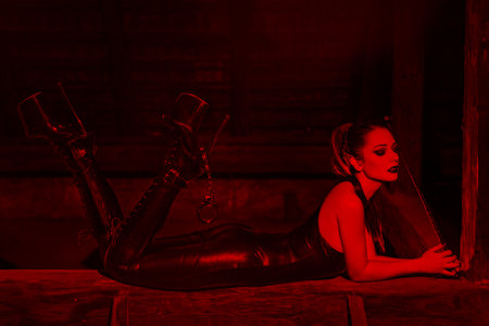 Sensual woman laying on timber in red light, desire, bdsmの写真素材