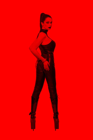 Sexy dominatrix in red light looking back, BDSM.の写真素材