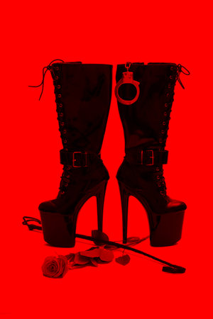 Black platform boots with whip and rose in red light, BDSMの写真素材