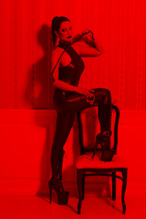 Sexy woman in latex catsuit at vintage wall, desire in red lightの写真素材