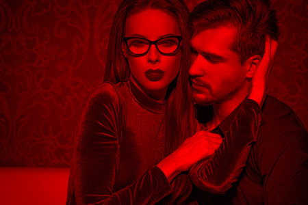 Sexy smart confident woman entice young rich man, playing with feelings, seductionの写真素材