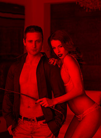 Sexy woman in underwear with whip posing with lover in red light, bdsmの写真素材