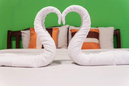 two  towels swans on white bedの写真素材