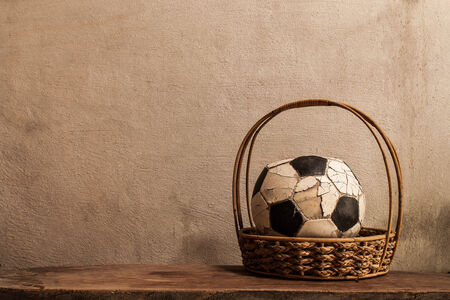 Old football in basket on concrete backgroundの写真素材