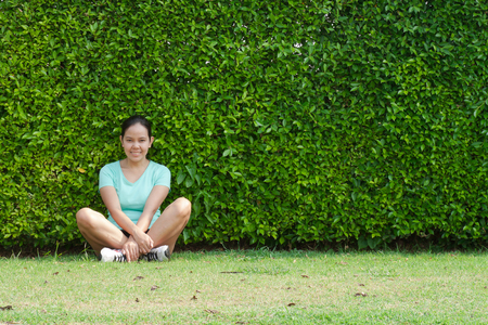 Jogging woman sitting after running in parkの写真素材