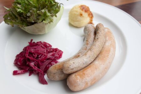Sausages and mashed potato and vegetable on white dishの写真素材
