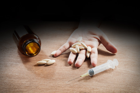 narcotic syringe and drugs in junkie handの写真素材
