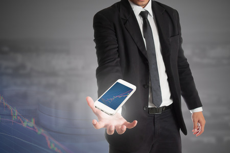 smart phone in  businessman hand with stock graph,concept of success in stock marketの写真素材