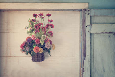 Artificial flowers on wood wallの写真素材