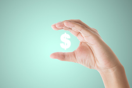 businessman hand holding  dollar sign on blue backgroundの写真素材