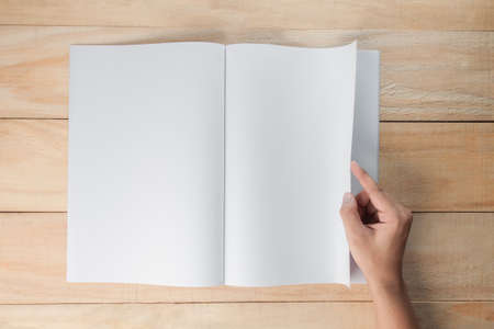 hand open blank book or magazines, book mock up on wood backgroundの写真素材
