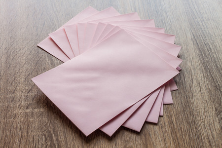 Blank pink envelopes on wood table